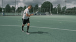 Mirco Pruyser on a hockey field holding a black and white hockey stick. 