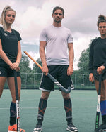 Mirco Pruyser standing in between two girls with a gray shirt on.
