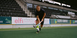 Field hockey player on field in action.