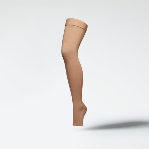 Front view of a medical thigh high stocking in sand.