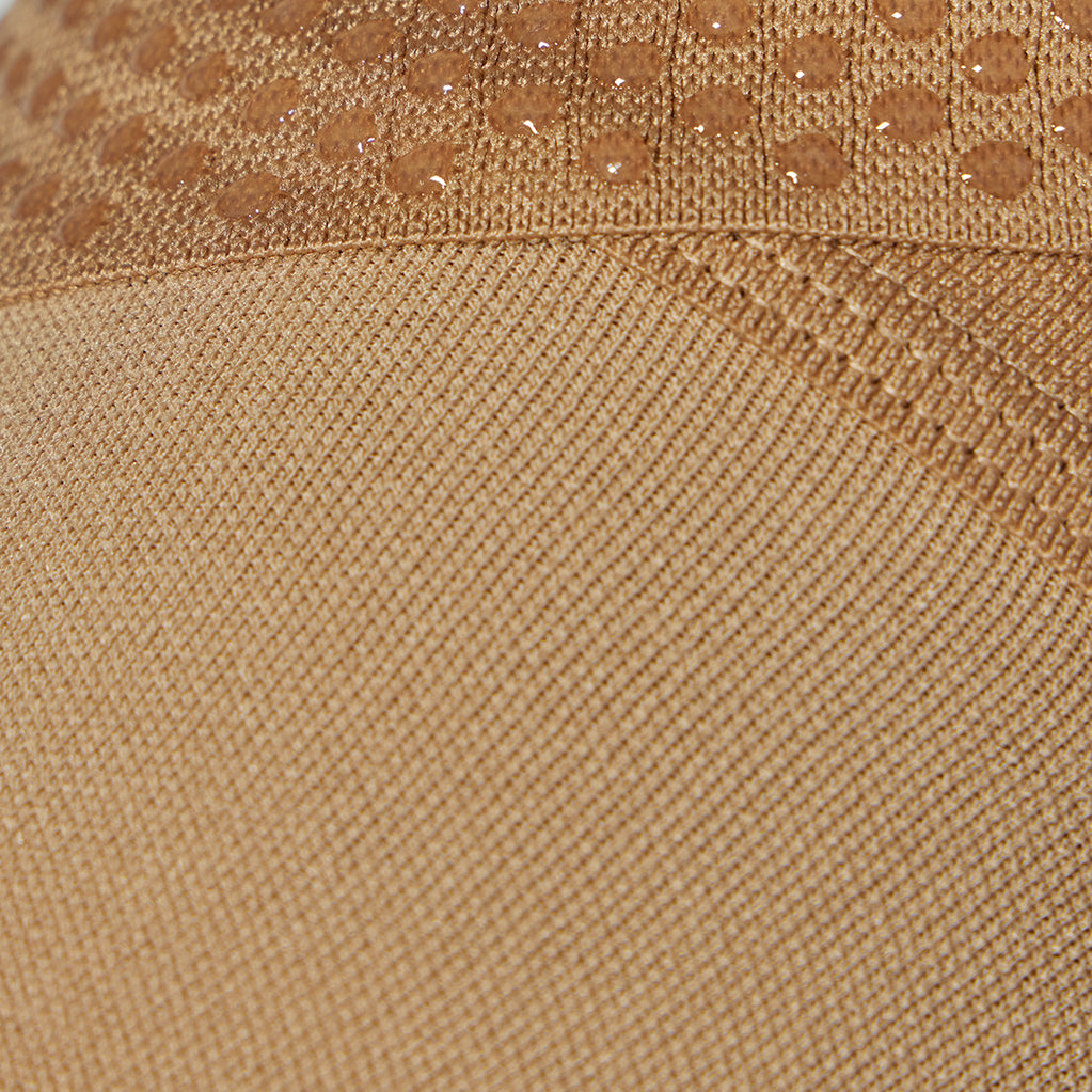 Detailed view of a medical thigh high stocking in a sand color.