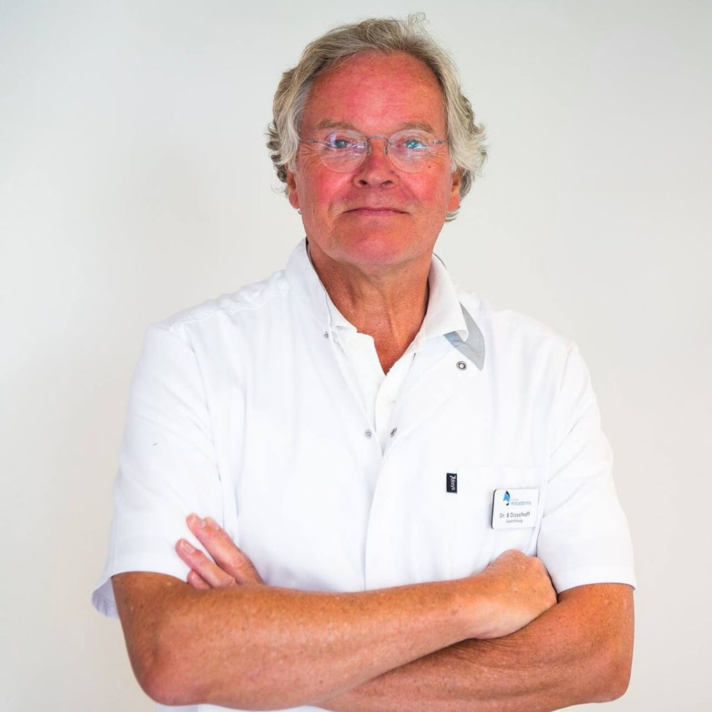 Man wearing white doctor's coat with his arms folded over each other.
