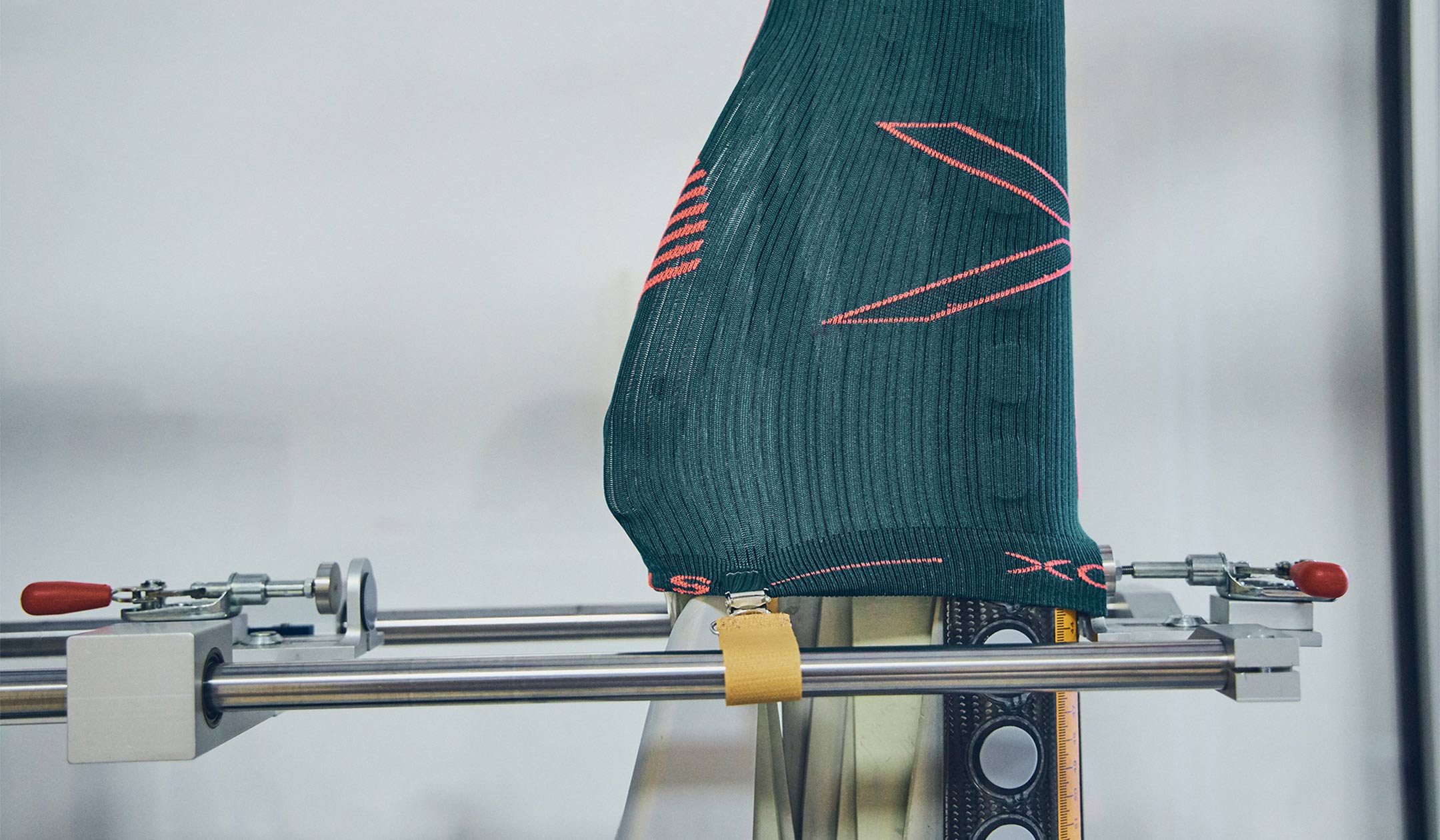 Green sock being measured on a technical machine. 