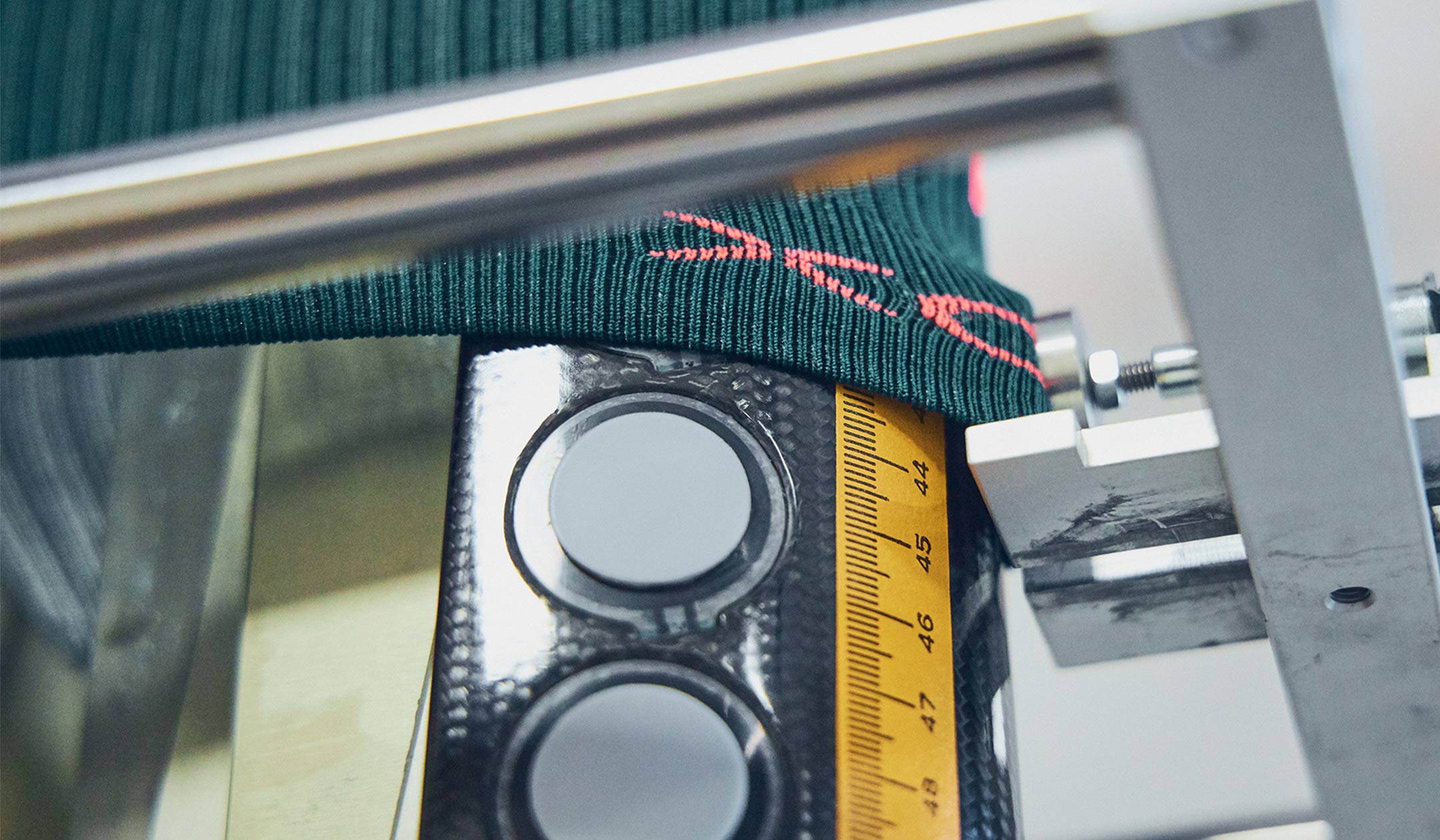 Detailed shot of a sock being pulled over a measuring tape.